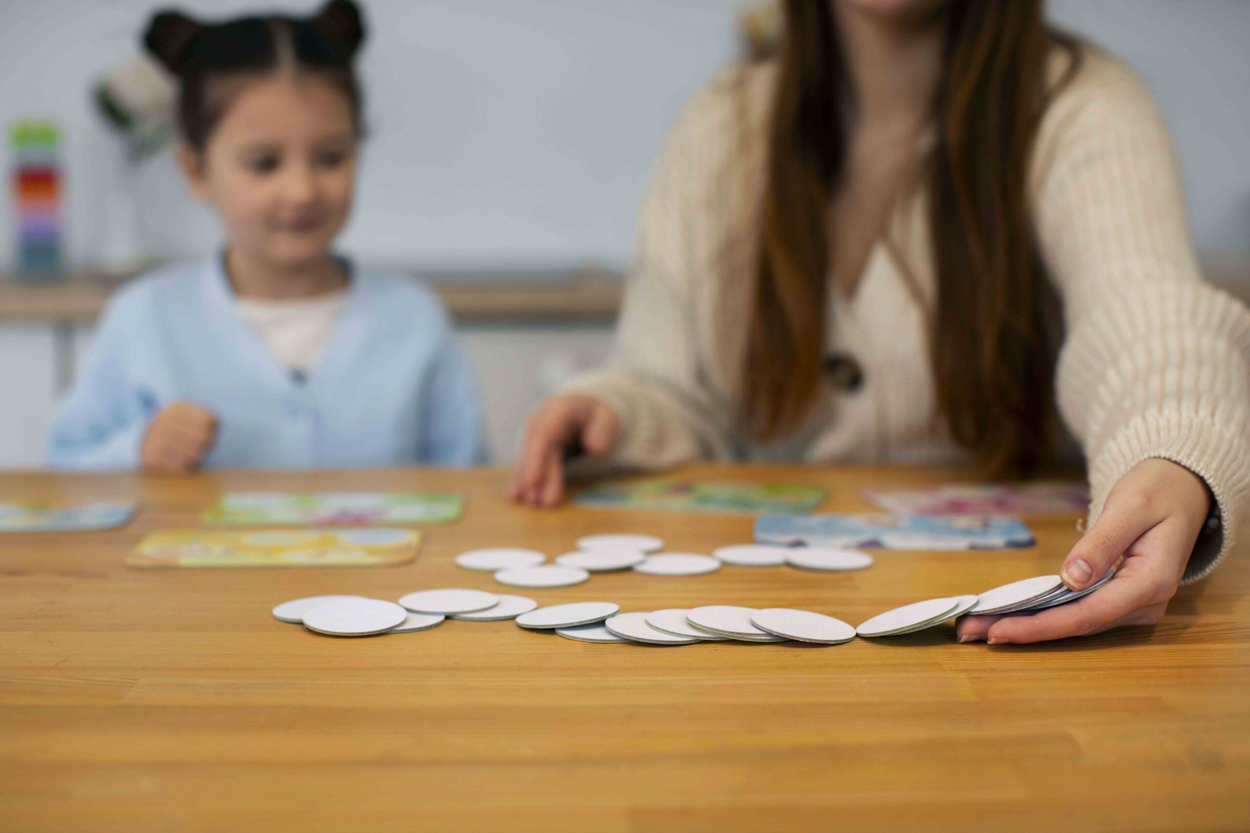niña jugando con maestra en mesa